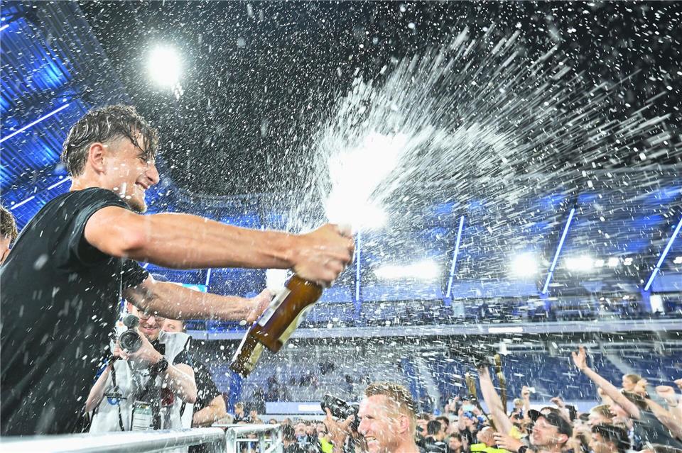  Arena. Spieler von SC Paderborn 07 spritzt mit einer Sektflasche im Stadion.Swen Pförtner/dpa