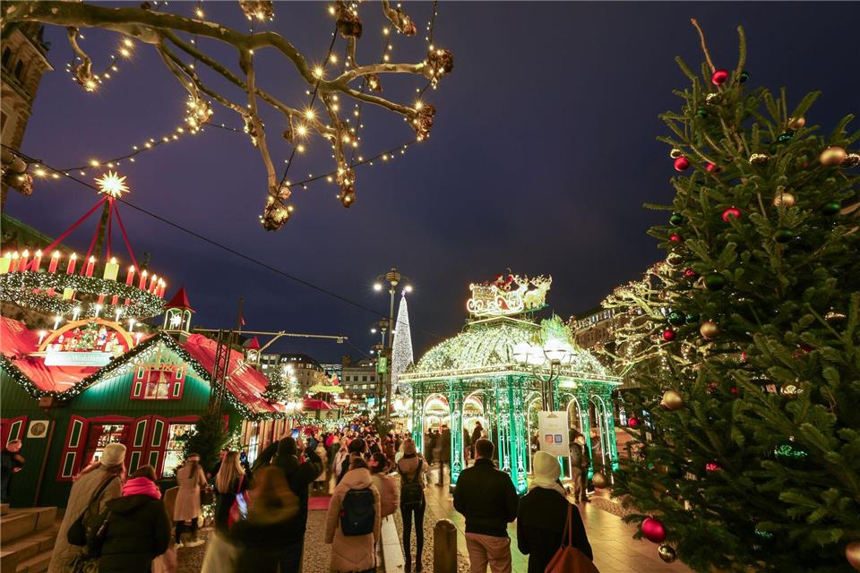  Besucher laufen über den Weihnachtsmarkt. Christian Charisius/dpa