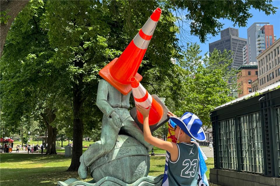  Ein schottischer Fußball-Fan setzt einer Statue in der Stadt Verkehrskegel auf.Jordan Raza/dpa