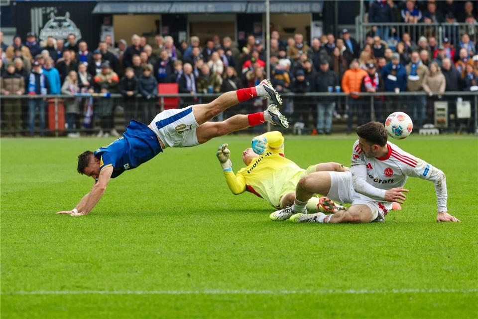  Kiels Adrian Kapralik (l) und Nürnbergs Torwart Jan Reichert in einem schmerzhaften Zweikampf.Frank Molter/dpa