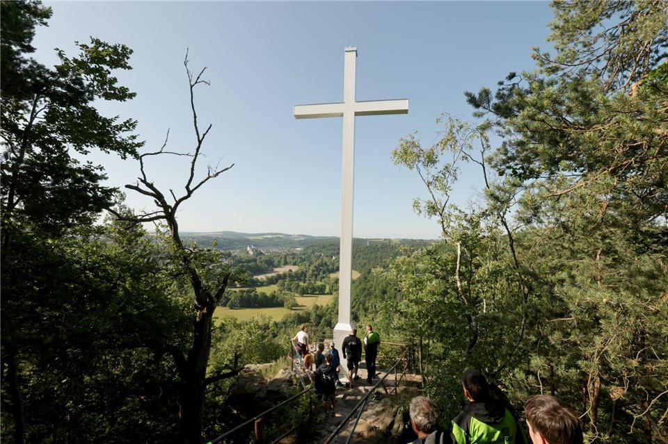 12 Meter hoch und 1,2 Tonnen schwer: Die Stadt Greiz hat ihr Wahrzeichen zurück. Ein Hubschrauber hat das Sophienkreuz, auch „Weißes Kreuz“ genannt, am Samstagmorgen zu dem schwer zugänglichen Aussichtspunkt auf dem Hirschstein gebracht. Dort thront das denkmalgeschützte Kreuz bereits seit 1838. Sturm und Witterung hatten dem 1985 installierten, alten Kreuz stark zugesetzt.Bodo Schackow/dpa