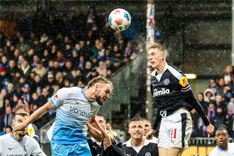 Bilder des Tages  2. Liga in Kiel: Bernhardsson (r, Kiel) und Strompf (Bochum) kämpfen bei Regen um jeden Ball.Frank Molter/dpa