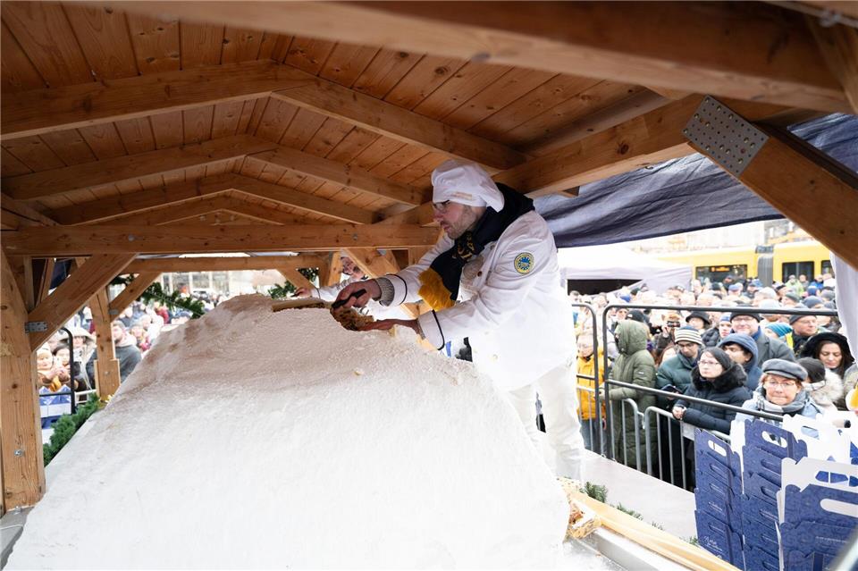 2,8 Meter lang und mehr als zwei Tonnen schwer: der Riesenstollen wird beim Dresdner Stollenfest in Stücke geschnitten.Sebastian Kahnert/dpa