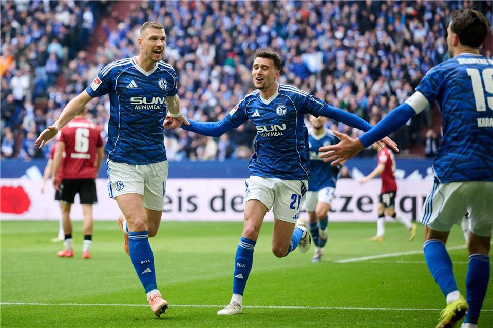 29. Minute: Edin Dzeko (links) erzielt das 1:0 für Schalke. Dejan Ljubicic und Vorbereiter Kenan Karaman (rechts) jubeln mit.Bernd Thissen/dpa