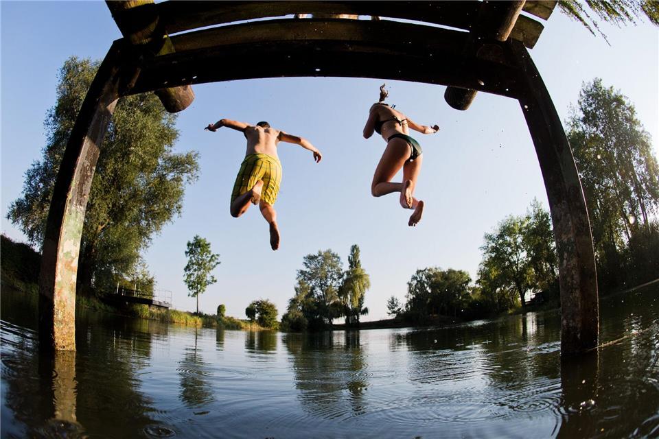 Ab ins Wasser! Springen sollte man jedoch nur, wenn das Gewässer dafür tief genug ist und man sich vorher abgekühlt hat. picture alliance / Julian Stratenschulte/dpa