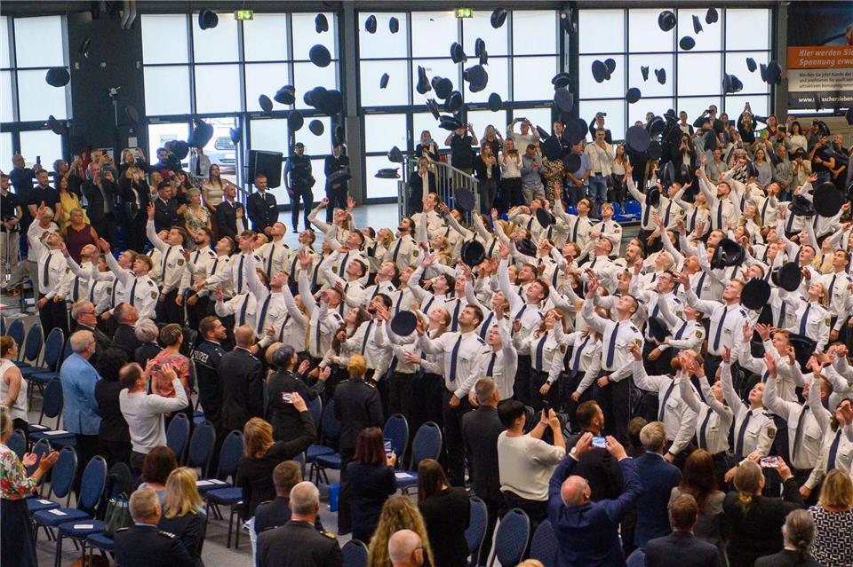 Absolventen der Fachhochschule Polizei Sachsen-Anhalt werfen ihre Dienstmützen in die Luft.Klaus-Dietmar Gabbert/dpa