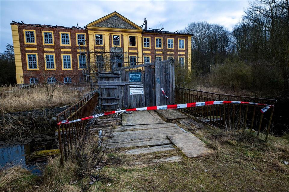 Absperrband und ein Holzverschlag versperren den Weg zum Wasserschloss Johannstorf. Jens Büttner/dpa