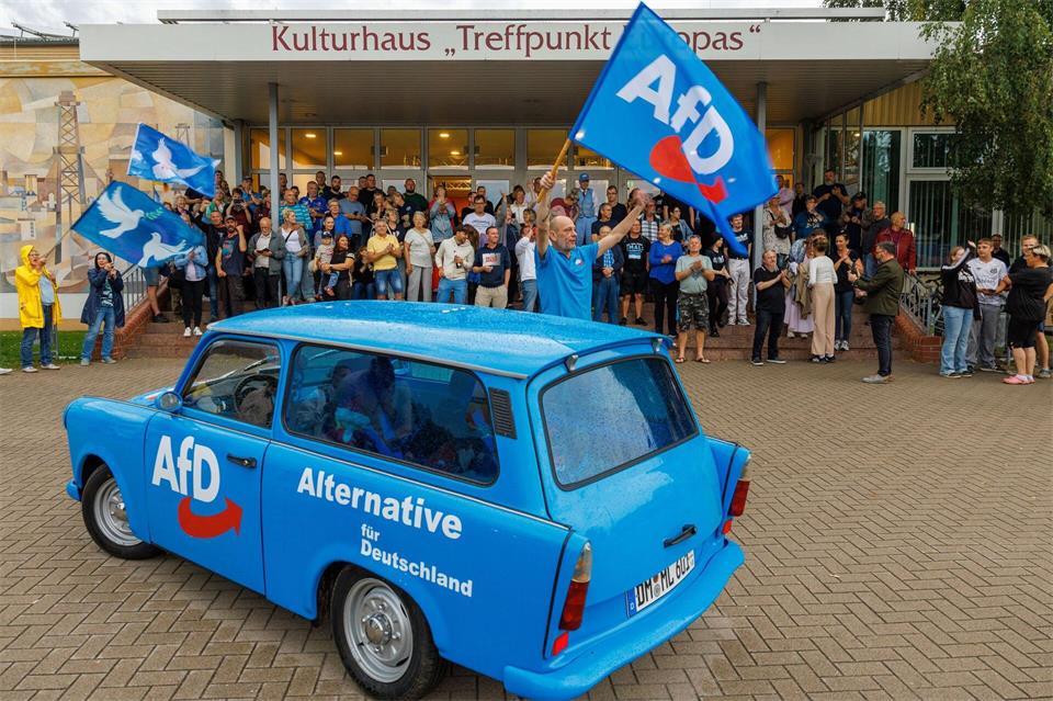 AfD-Anhänger feiern in Grimmen kurz vor einer Wahlveranstaltung der Partei. Jens Büttner/dpa