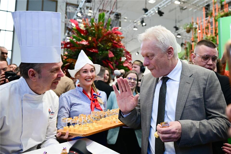 Agrarminister Alois Rainer kostet beim Eröffnungsrundgang Käse. Sebastian Christoph Gollnow/dpa