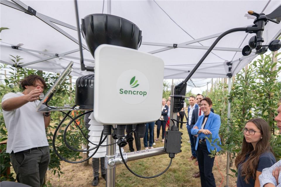 Agrarministerin Silke Gorißen (3.v.r, CDU) lässt sich eine Wetterstation in einer Apfelplantage am Campus Klein-Altendorf zeigen.Benjamin Westhoff/dpa