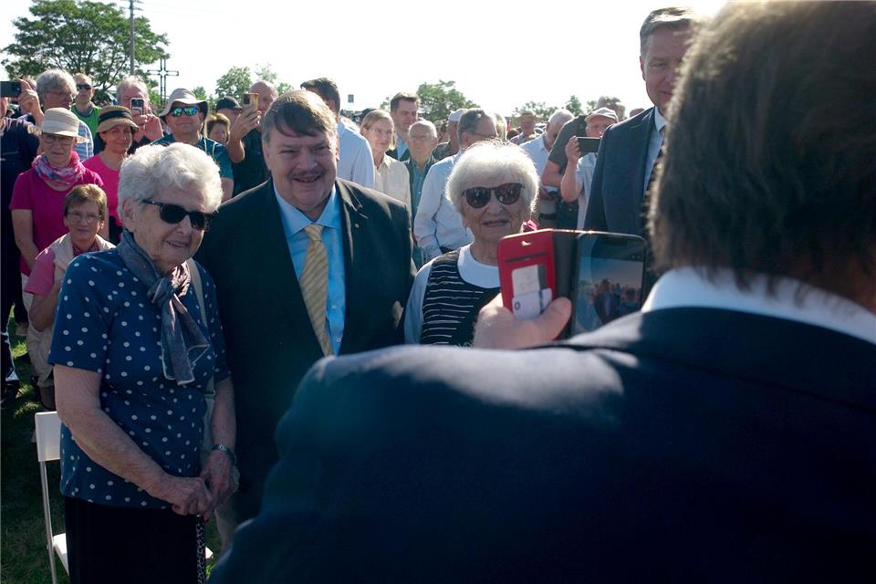 Alexander Dobrindt (CSU, r), Bundesinnenminister, macht selbst ein Handyfoto vom Sprecher der Sudetendeutschen Volksgruppe, Bernd Posselt (M), und Teilnehmerinnen bei einem Gedenken an die Opfer der Vertreibung nach dem Zweiten Weltkrieg im tschechischen Pohorelice bei Brünn (Brno).Michael Heitmann/dpa