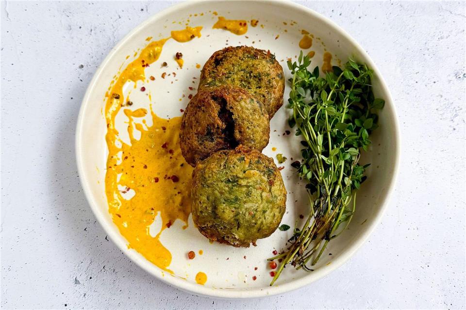 Als „Berliner Falafel mit Curry-Tahini-Sauce“ wurden diese Bällchen im „Gemeinsam Kochen ohne Grenzen“ getauft. Die Falafel sind aus 400 g gekochten weißen Bohnen gemacht. Elissavet Patrikiou/Südwest Verlag/dpa-tmn