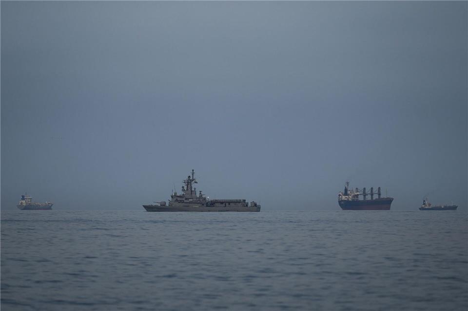 Als Folge des Iran-Krieges ist die für Öllieferungen wichtige Straße von Hormus nahezu blockiert. Hier patrouilliert ein Marine-Schiff der Vereinigten Arabischen Emirate neben Frachtschiffen und Öltankern dort.Altaf Qadri/AP/dpa