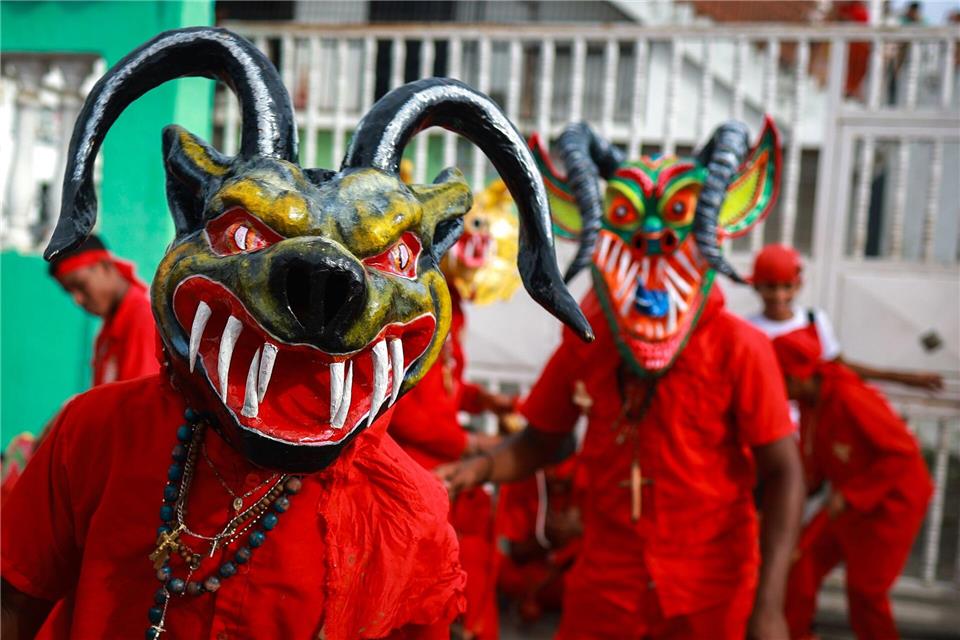 Als Teufel verkleidete Männer nehmen in Venezuela an einem traditionellen Volksfest zu Fronleichnam teil. Javier Campos/dpa