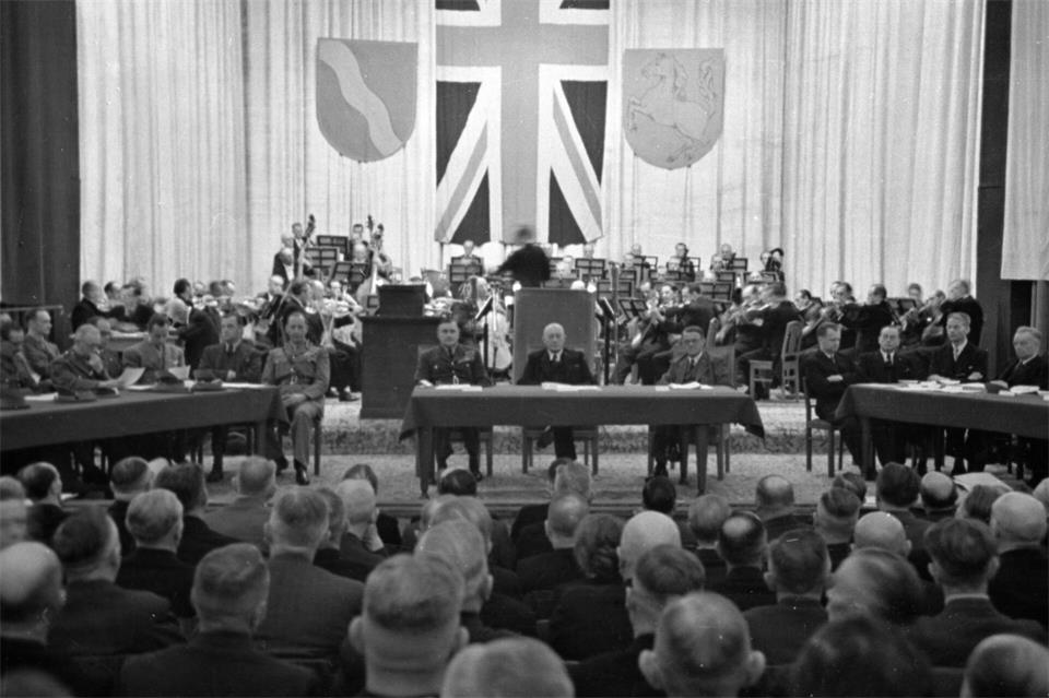 Am 12. und 13. Oktober 1946 trat der erste Landtag Nordrhein-Westfalens zusammen. Deutlich war die Prägung der britischen Besatzer, nicht zuletzt auch durch den „Union Jack“ und zahlreiche Militärs. Das Bild zeigt einen Ausschnitt eines Bild, das ein Pressefotograf vor 80 Jahren anfertigte.