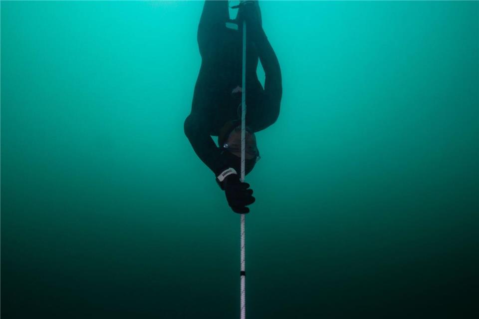 Am Seil zieht sich der Apnoe-Taucher Minja Marinković bis auf 85 Meter in die Tiefe. Samuel Mauch/dpa