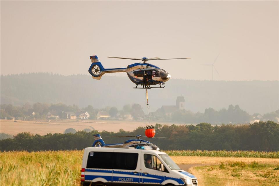 Am Tag bekommen die Einsatzkräfte am Boden bei den Löscharbeiten auch Hilfe aus der Luft.Thomas Banneyer/dpa