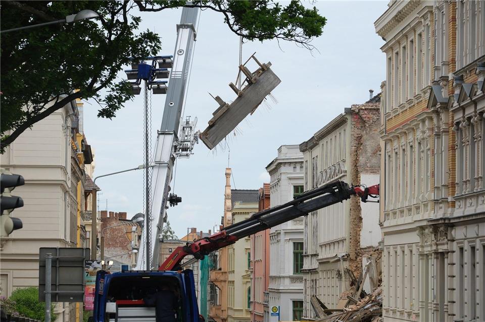 An dem eingestürzten Haus in Görlitz werden Trümmerteile mit einem Kran geborgen. Sebastian Willnow/dpa