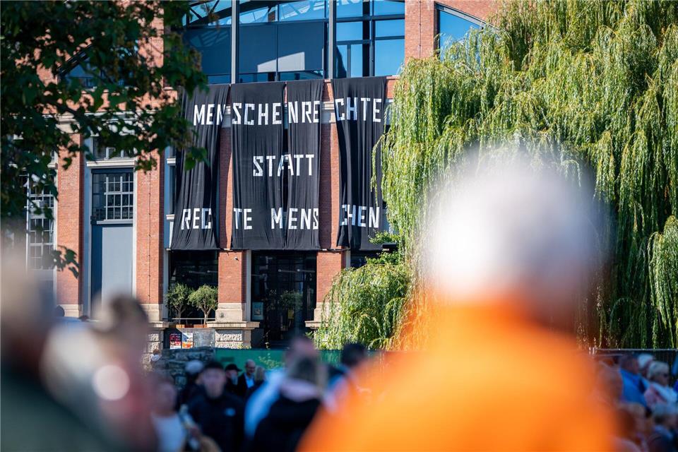 An der Fassade der Zentralheize in Erfurt hängt ein Banner mit der Aufschrift „Menschenrechte statt rechte Menschen“. Jacob Schröter/dpa