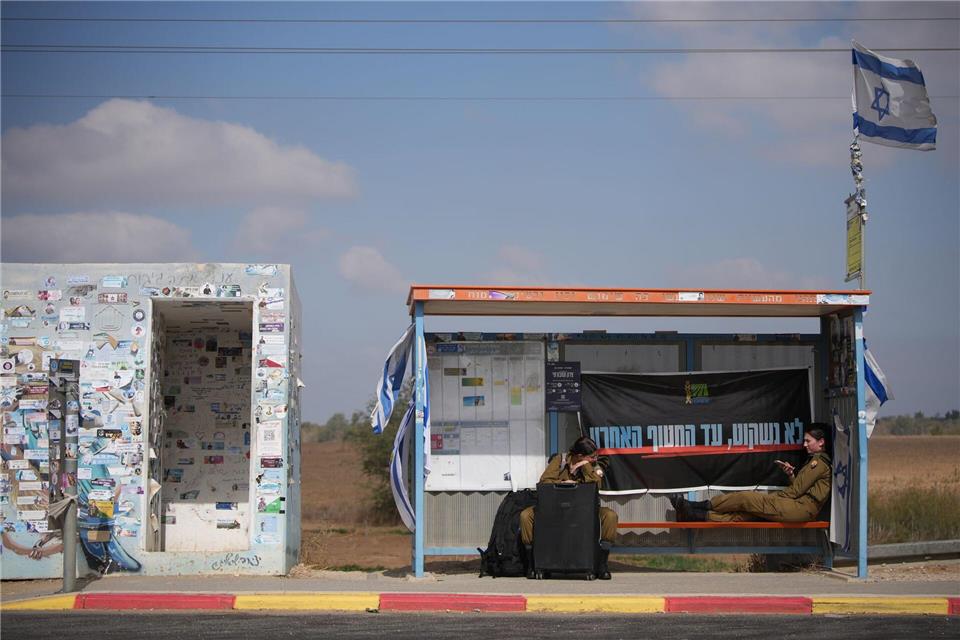 Bilder des Tages  An einem Busbahnhof nahe der Grenze zum Gazastreifen warten israelische Soldatinnen auf den Transport.Ohad Zwigenberg/AP/dpa