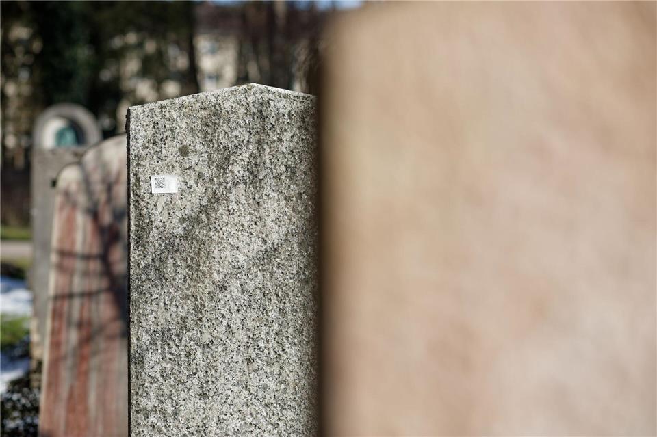 An etwa 1.000 Gräbern in München tauchten schwer abzulösende Aufkleber auf, die zu digitalen Daten über das Grab führen.Tizian Gerbing/dpa