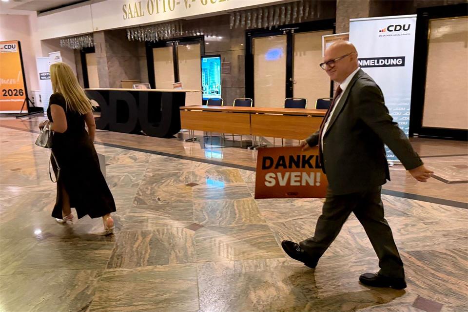 Andenken an einen denkwürdigen Abend: AfD-Co-Fraktionschef Oliver Kirchner geht mit einem Plakat von CDU-Ministerpräsident Sven Schulze durch ein Hotelfoyer. Simon Kremer/dpa