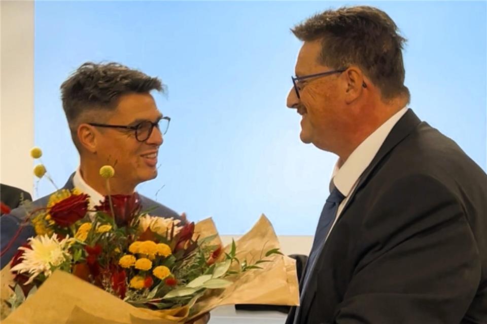 Andre Olbing (r.) gratuliert dem neuen Bürgermeister Dirk Kuhmann nach der Vereidigung.