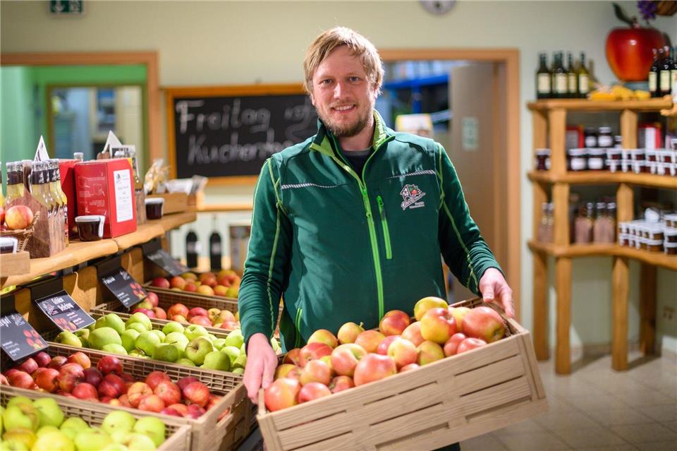 André Stallbaum vom Stendaler Scheunenladen steht mit einer Kiste Äpfel in seinem Hofladen.Klaus-Dietmar Gabbert/dpa