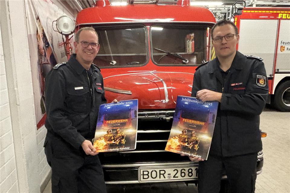 Andre Szczesny (l.), der Leiter der Raesfelder Feuerwehr, und Thorsten Meis, der die Planung des Jubiläums koordiniert, zeigen den Kalender, der zum 125-jährigen Bestehen der Wehr herausgegeben worden ist.