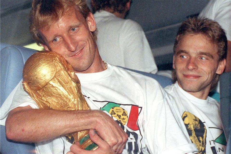 Andreas Brehme (l) mit dem WM-Pokal nach dem Finalsieg 1990 gegen Argentinien. Rechts daneben sein Mitspieler Thomas Häßler.