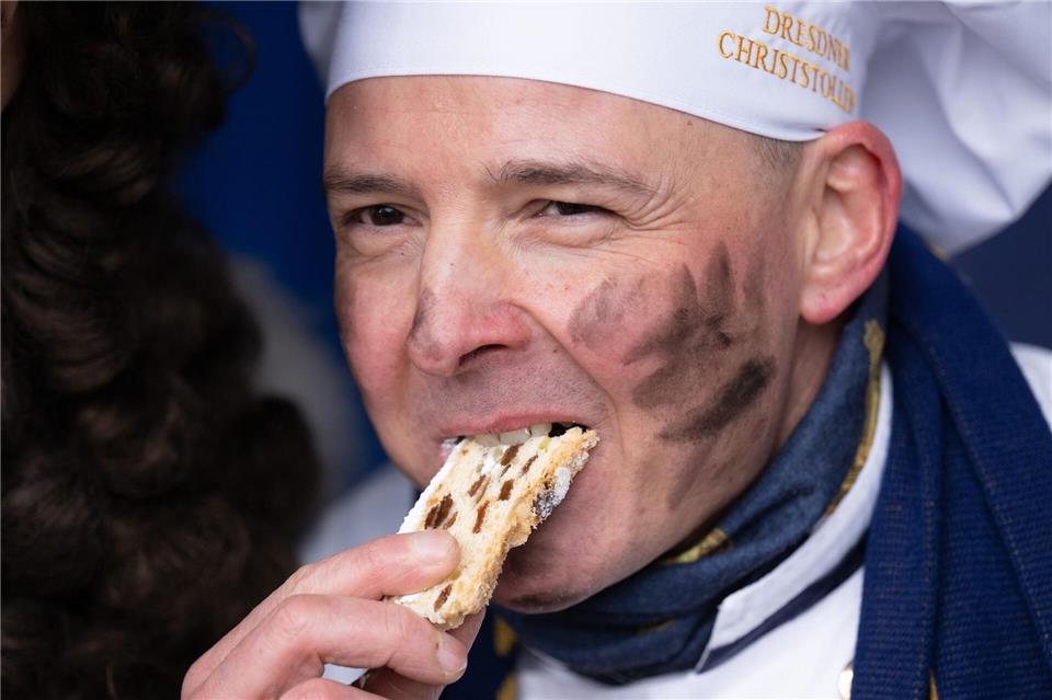 Andreas Wippler, Vorstandsvorsitzender Schutzverband Dresdner Stollen, verkostet ein Stück vom Riesenstollen.Sebastian Kahnert/dpa