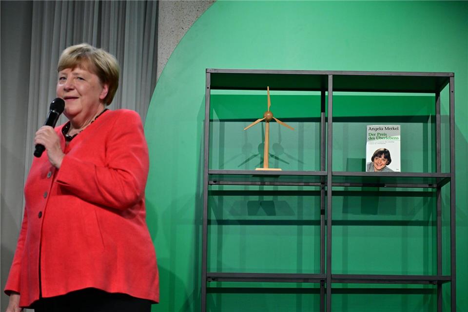 Angela Merkel (CDU), Bundeskanzlerin a.D. und ehemalige Bundesumweltministerin, spricht auf der Bühne beim Festakt „Seit 40 Jahren NaturVerbunden“ zum 40. Jubiläum des Bundesumweltministeriums im Café „Moskau“, während im Hintergrund ihr Buch mit dem Titel „Der Preis des Überlebens“ zu sehen ist.Sebastian Christoph Gollnow/dpa