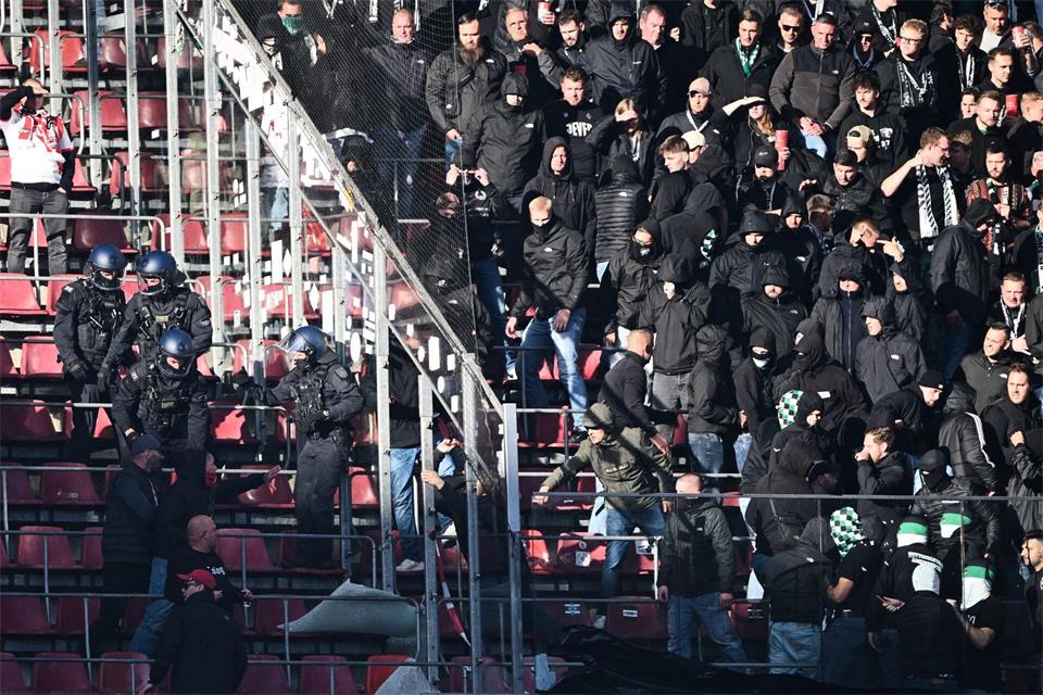 Anhänger von Borussia Mönchengladbach treten eine Schutzscheibe ein. Federico Gambarini/dpa