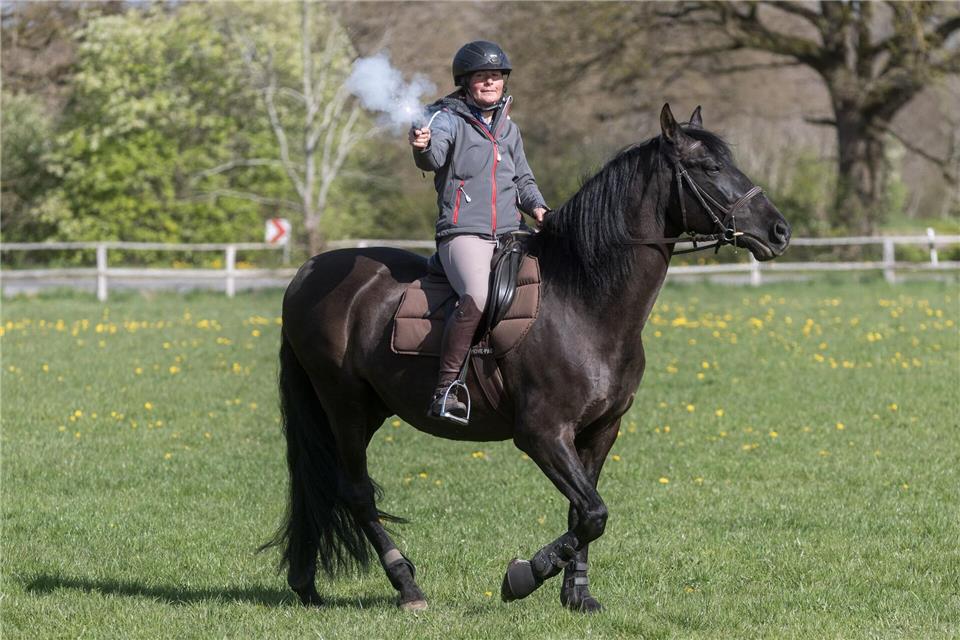 Anna Weiler feuert auf dem Rappen Oro, der bei den Karl-May-Spielen Winnetous Pferd Iltschi darstellt, einen Schreckschuss-Revolver ab.Markus Scholz/dpa