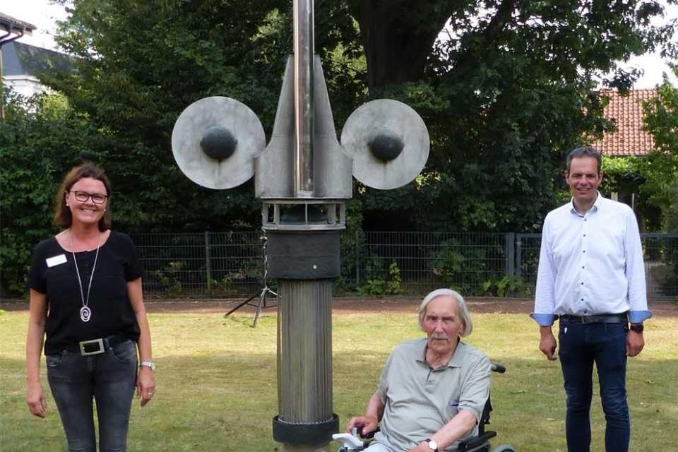 Anne Eversmann, Hermann Kunkler und Bürgermeister Andreas Grotendorst freuen sich über das Kunstwerk „Der Wächter“ im Garten des Seniorenhauses St. Martin.