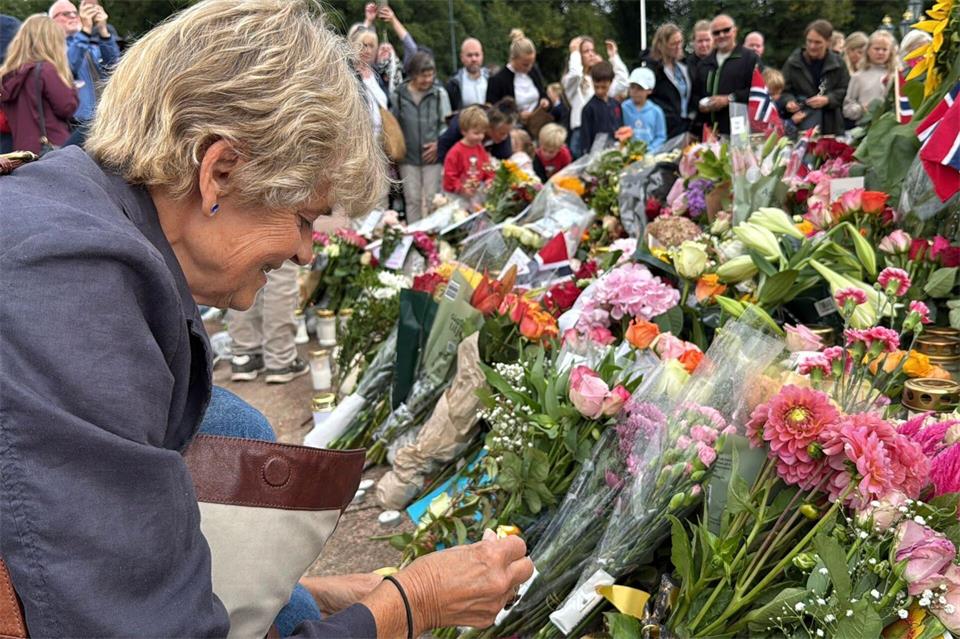Anne Sandø Seierstad zündet eine Kerze für den gestorbenen Monarchen an. Julia Wäschenbach/dpa