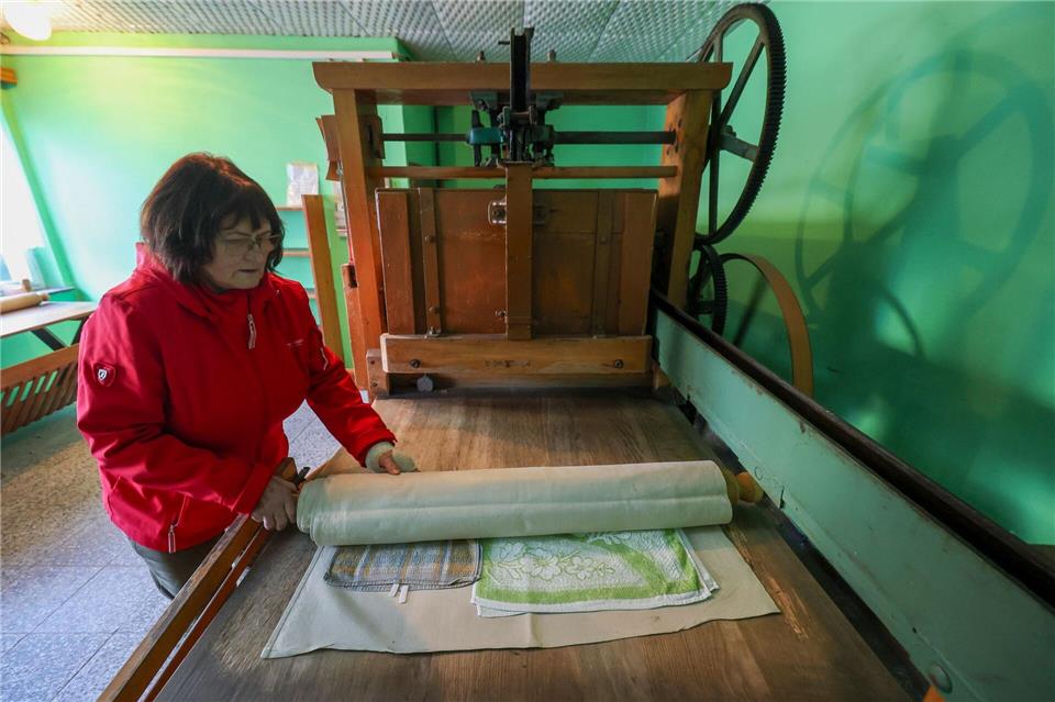 Annerose Illing mangelt die Wäsche ihrer betagten Mutter mit einer historischen Kaltmangel. Jan Woitas/dpa