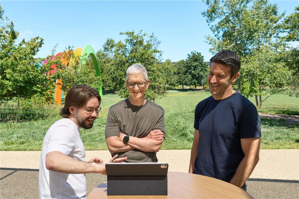 Anton Baranov (l) zeigte seine App sowohl Apple-Chef Tim Cook (M) als auch dessen designiertem Nachfolger John Ternus.-/Apple/dpa