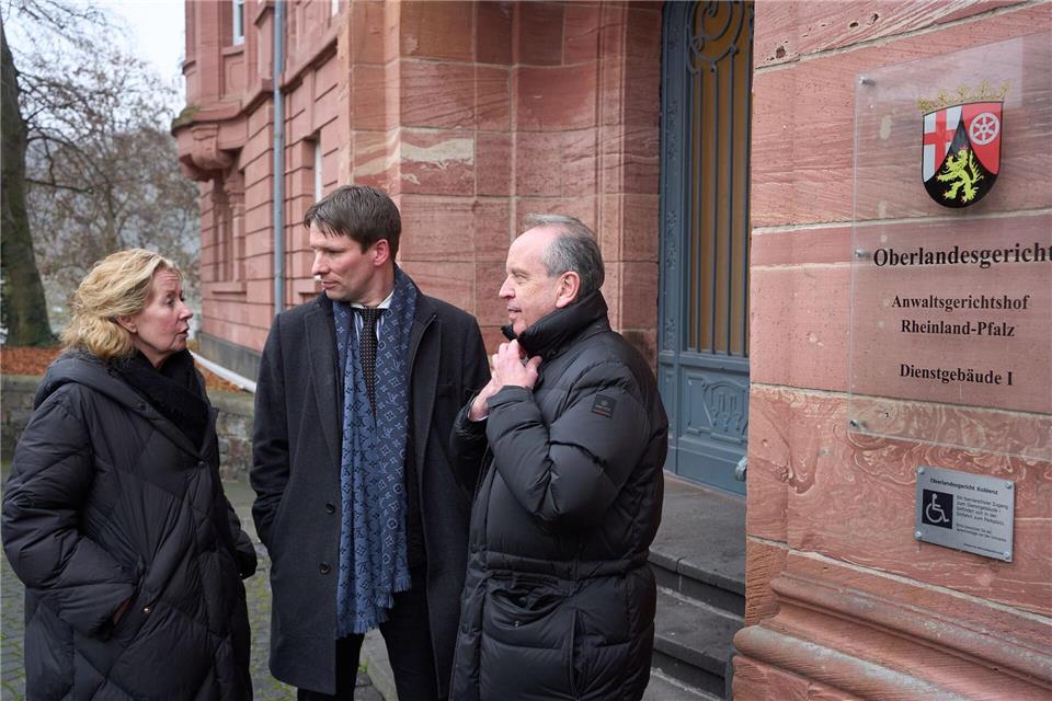 Anwalt Hecken (Mitte) steht mit den Eltern eines Flutopfers vor dem Koblenzer Oberlandesgericht. Thomas Frey/dpa