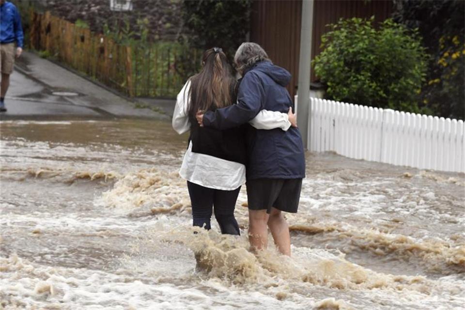 Anwohner der Ortschaft Balken helfen sich durch Fluten der Wupper. Foto: Roberto Pfeil/dpa