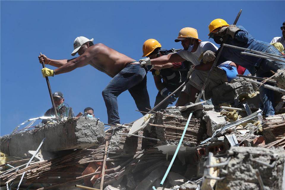 Anwohner und Rettungskräfte durchsuchen die Trümmer nach einem Erdbeben.Santiago Saldarriaga/AP/dpa