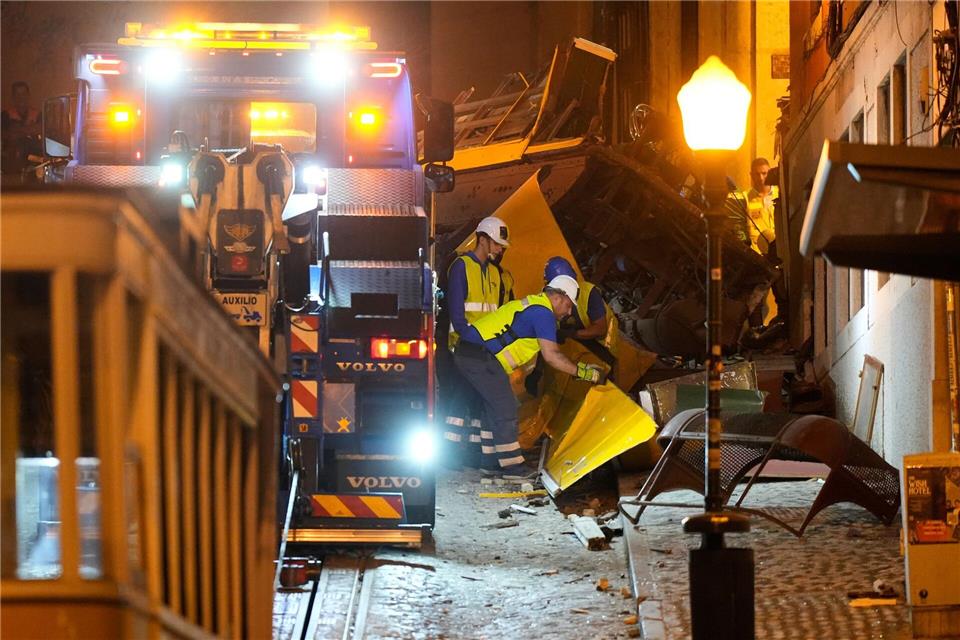 Bilder des Tages Arbeiter beseitigen die Trümmer einer entgleisten und verunglückten Standseilbahn in Lissabon.Ana Brigida/AP/dpa