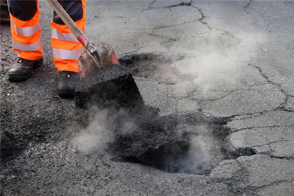 Arbeiter der Straßenmeistereien führen derzeit an vielen Stellen in ganz Deutschland Notreparaturen von Schlaglöchern durch. (Symbolbild)Bernd Wüstneck/dpa