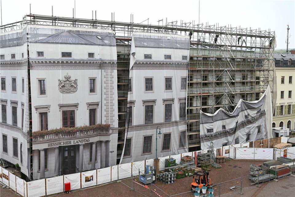 Arbeiter lassen 2021 eine fotorealistische Gerüstplane am Ostflügel des Wiesbadener Landtags zu Boden - nach einer damals abgeschlossenen Dachsanierung. (Archivbild)Arne Dedert/dpa