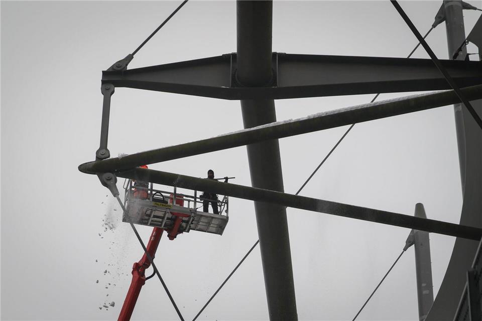 Arbeiter mit einem Hubsteiger entfernen Eis und Schnee von den Trägern des Stadiondachs in Hamburg.Christian Charisius/dpa