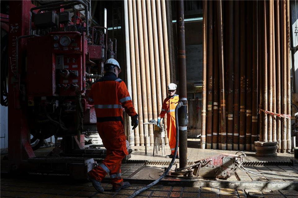 Arbeiter montieren im Bohrturm einen neuen Bohrstrang.Christian Charisius/dpa