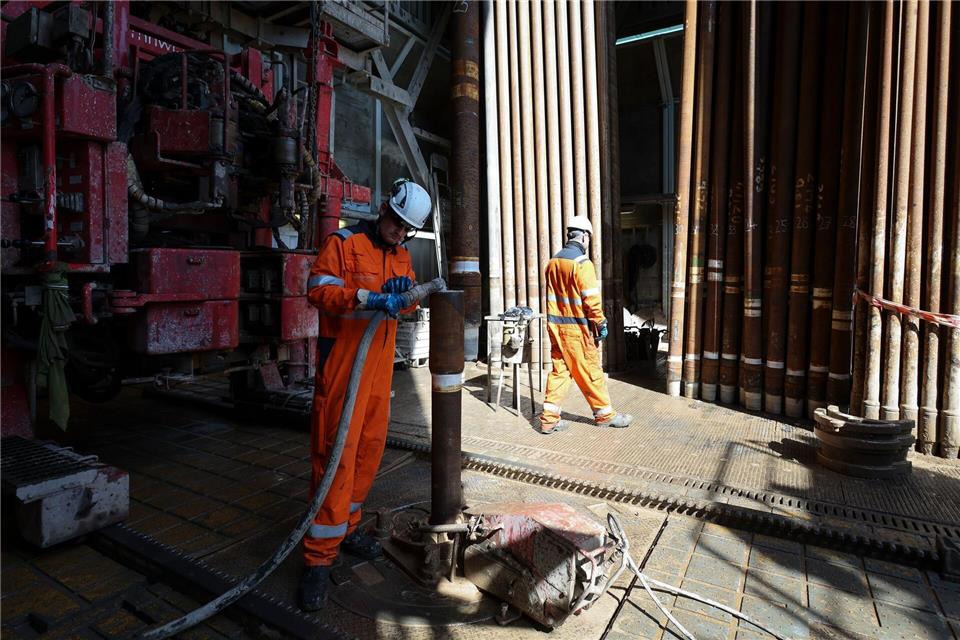 Arbeiter montieren im Bohrturm einen neuen Bohrstrang.Christian Charisius/dpa