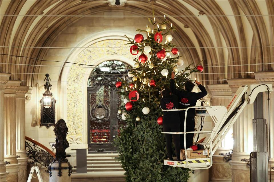 Arbeiter schmücken den Weihnachtsbaum in der Rathausdiele.Christian Charisius/dpa