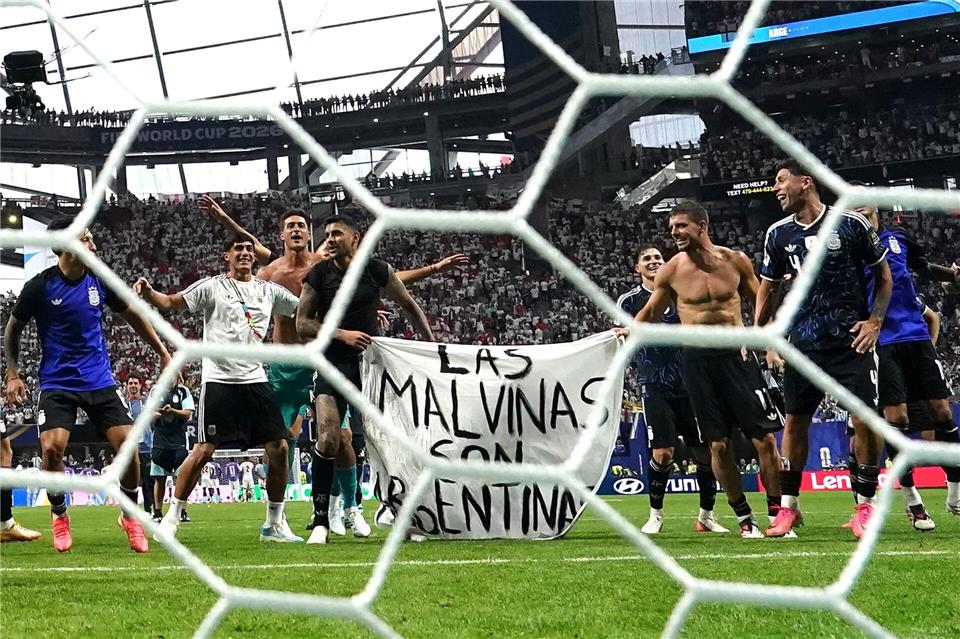Argentinische Spieler halten das Plakat nach dem WM-Finaleinzug hoch.Nick Potts/PA Wire/dpa