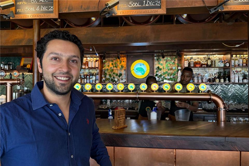 Arjun Malhotra steht an der Bar seines Biergartens „Crafty Chameleon“.Eva Krafczyk/dpa